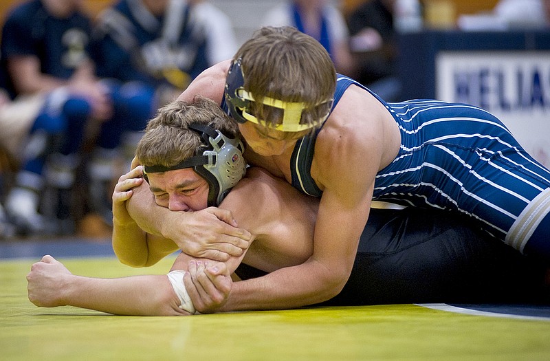 Helias' Jacob Schulte holds down Tyler Janes of Hannibal during their 132 pound match Wedenesday at Rackers Fieldhouse. Helias defeated Hannibal and Warrenton.