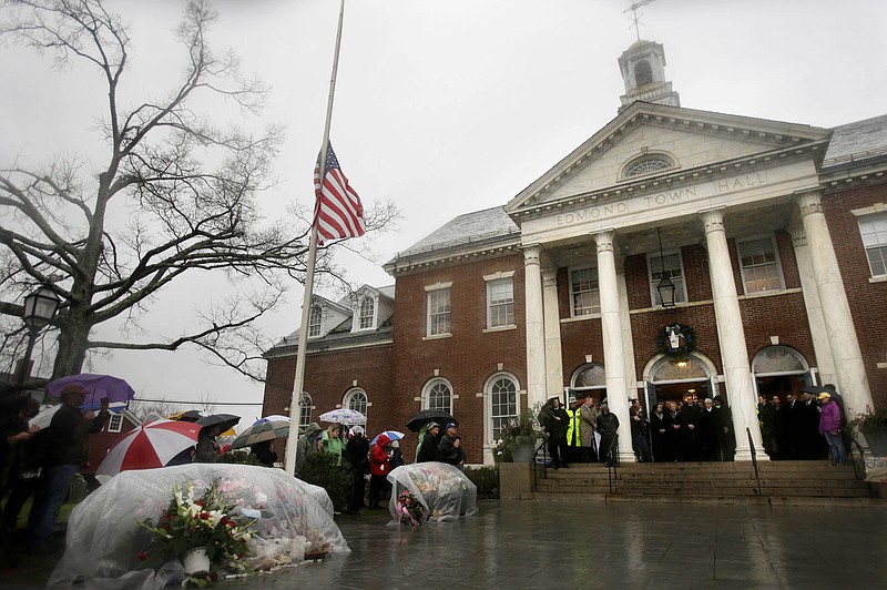 Officials, including Connecticut Governor Dan Malloy, observe a moment of silence Friday on the steps of Edmond Town Hall while bells ring 26 times in Newtown, Conn. The chiming of bells reverberated throughout Newtown, commemorating one week since the crackle of gunfire in a schoolhouse killed 20 children and six adults.