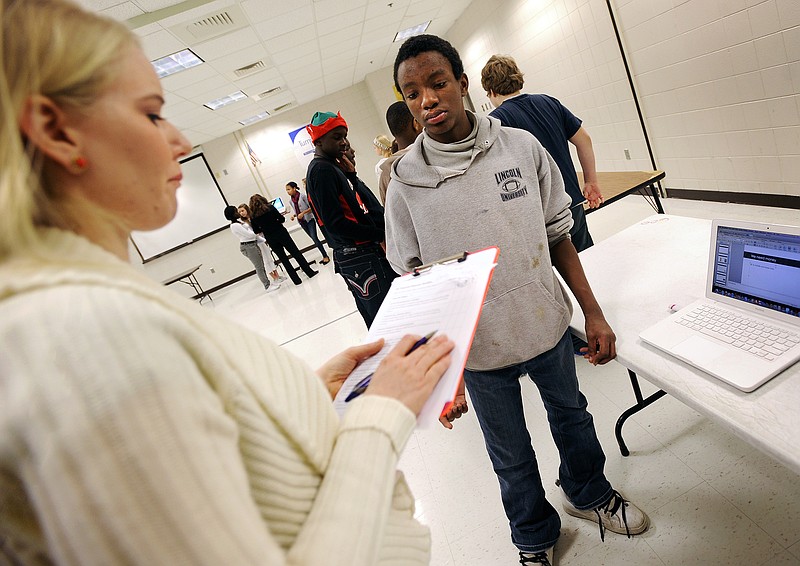 Thomas Jefferson Middle School seventh-grader Deve Scoffield watches as his social studies teacher Ashley Schlender evaluates his presentation on the comparison of ancient Chinese social classes to the current economic situation in the United States on Wednesday. Using a teaching method called "project-based learning," Schlender posed the question to her students, "What big ideas from ancient China can be used to improve Jefferson City."