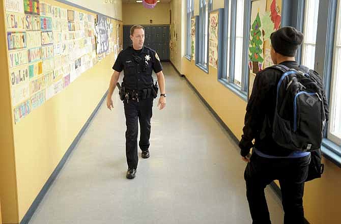  In this Dec. 17, 2012 photo, Officer Rick Moore of the Oakland school district police patrols Oakland Technical High School in Oakland, Calif.