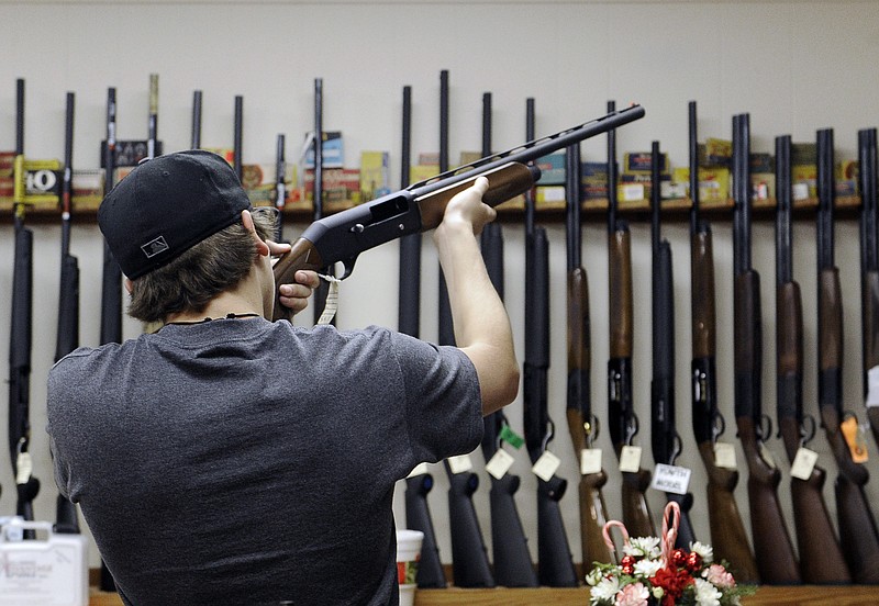 A customer checks out a shotgun at Burdett & Son Outdoor Adventure Shop in College Station, Texas. More civilians are armed in the U.S. than anywhere else in the world, with Yemen coming in a distant second, according to the Small Arms Survey in Geneva.