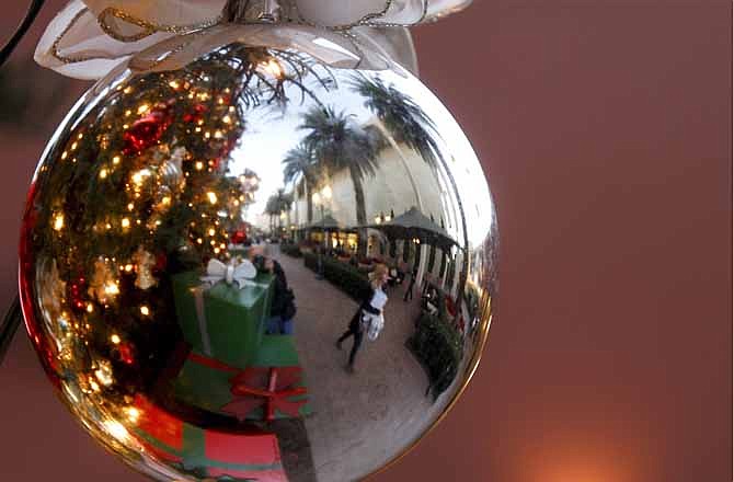 In this Thursday, Dec. 20, 2012, photo, a holiday shoppers reflected in a ornament handing from a large Christmas tree at Fashion Island shopping center in Newport Beach, Calif. Thursday, Dec. 20, 2012. U.S. holiday retail sales this year are the weakest since 2008, after a shopping season disrupted by storms and rising uncertainty among consumers. A report out Tuesday that tracks spending, called MasterCard Advisors SpendingPulse, says holiday sales increased 0.7 percent. Analysts had expected sales to grow 3 to 4 percent.