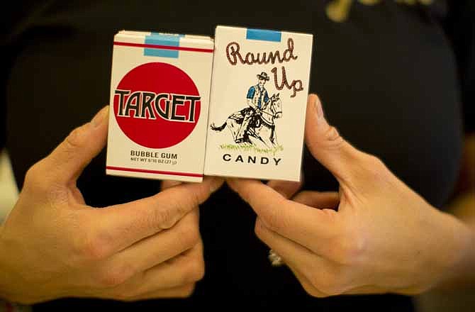 Co-owner of Lynden's Soda Fountain, Tobi Lynden, holds boxes of candy cigarettes, in St. Paul, Minn., Wednesday, Dec. 26, 2012. Lynden's Soda Fountain was cited for selling candy cigarettes to kids. The candy cigarettes are no longer displayed or sold.