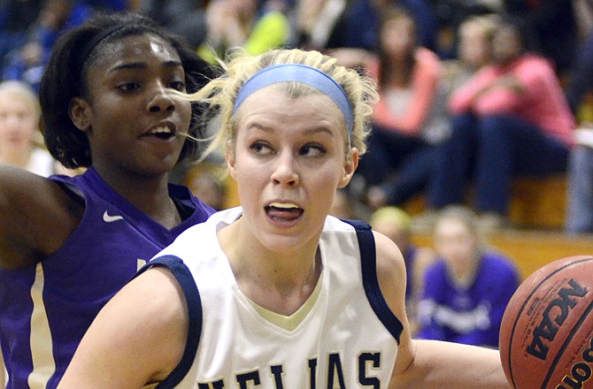 Helias' Emma Verslues drives along the baseline and against Louisville Male's Jasmine Kraft during the State Farm Holiday Hoops Invitational on Thursday at Rackers Fieldhouse.