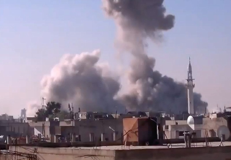 Smoke rises from buildings from heavy shelling in Homs, Syria, on Thursday.