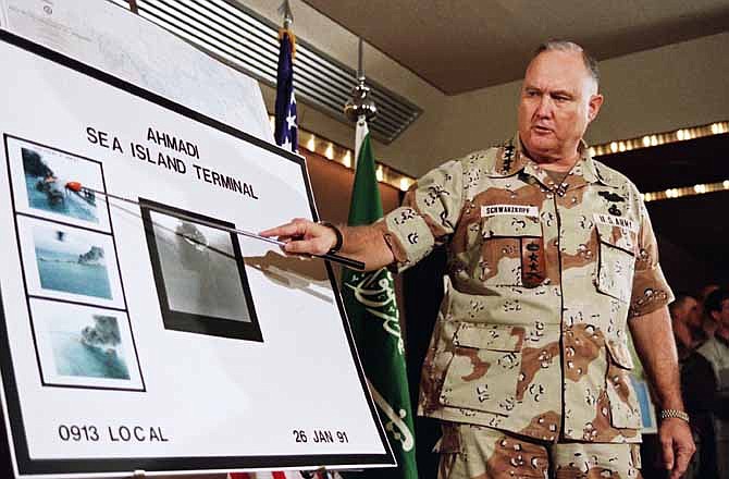 In this Jan. 27, 1991 file photo, U.S. Army Gen. Norman Schwarzkopf points to row of photos of Kuwait's Ahmadi Sea Island Terminal on fire after a U.S. attack on the facility. Schwarzkopf died Thursday, Dec. 27, 2012 in Tampa, Fla. He was 78. 