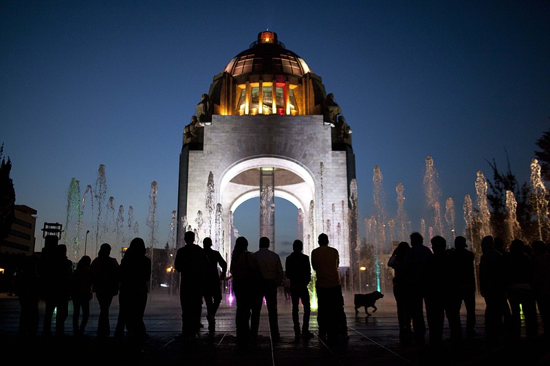 Pedestrians stand in front of the Arch of the Revolution monument in Mexico City. The once-neglected plaza with an Arc de Triumph-style monument to Mexico's 1910 revolution has been remade from a homeless encampment to a place where families visit and children run through spurts of water gushing out of the pavement. Mexico City's government is trying to transform one of the world's largest cities by beautifying public spaces, parks and monuments. 