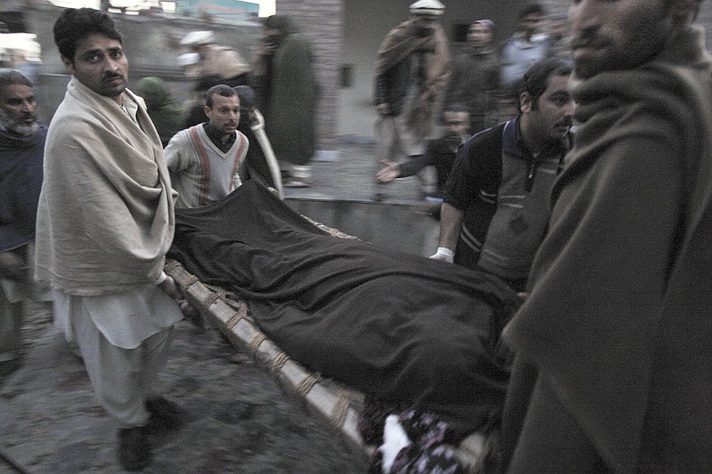 Pakistani men carry the body of a teacher, who was killed Tuesday by gunmen, from a hospital for burial in Swabi, Pakistan. Gunmen in northwest Pakistan killed five female teachers and two aid workers on Tuesday in an ambush on a van carrying workers home from their jobs at a community center, officials said. 