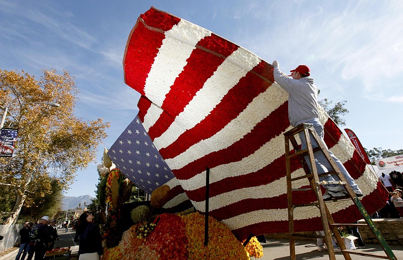 Volunteer David Burney from Milwaukee helps put the finishing touches on the RDF TV rose float Monday in Pasadena.