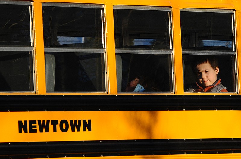 A boy sits on a Newtown bus leaving the new Sandy Hook Elementary School on Thursday after the first day of classes in Monroe, Conn.  The Sandy Hook students started Thursday in a new school, formerly called Chalk Hill School in Monroe.  It was renamed Sandy Hook Elementary and overhauled especially for the students from the Sandy Hook School shooting.