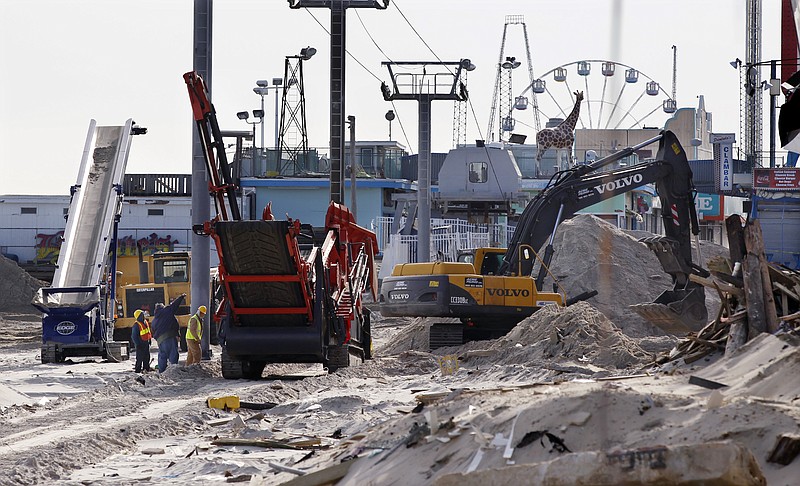 Crews work Thursday to replace the Superstorm Sandy destroyed boardwalk in Seaside Heights, N.J. Under intense pressure from angry Republicans. Congress rushed an aid package to help pay flood insurance claims.