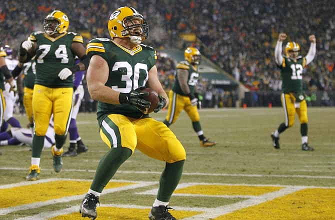 Green Bay Packers fullback John Kuhn celebrates after scoring a touchdown during the first half of an NFL wild card playoff football game against the Minnesota Vikings Saturday, Jan. 5, 2013, in Green Bay, Wis.