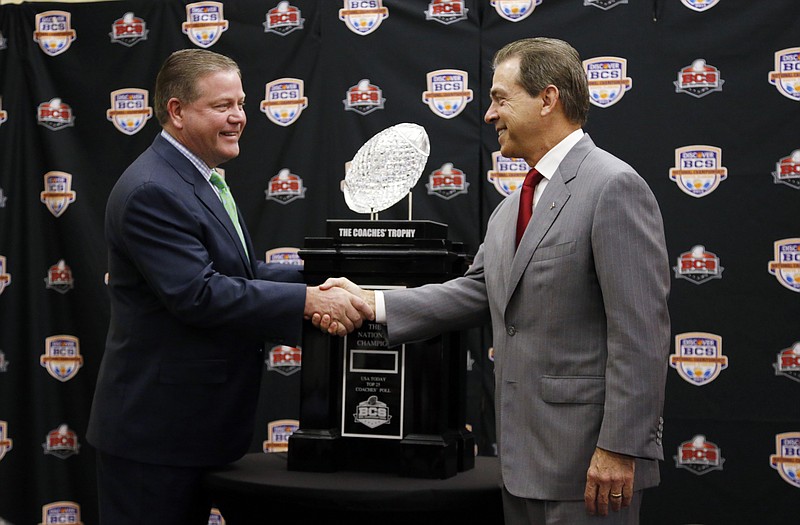 Alabama head coach Nick Saban (right) and Notre Dame head coach Brian Kelly pose with The Coaches' Trophy during a news conference for the BCS National Championship on Sunday in Miami. The Tide and Fighting Irish meet today for the title.