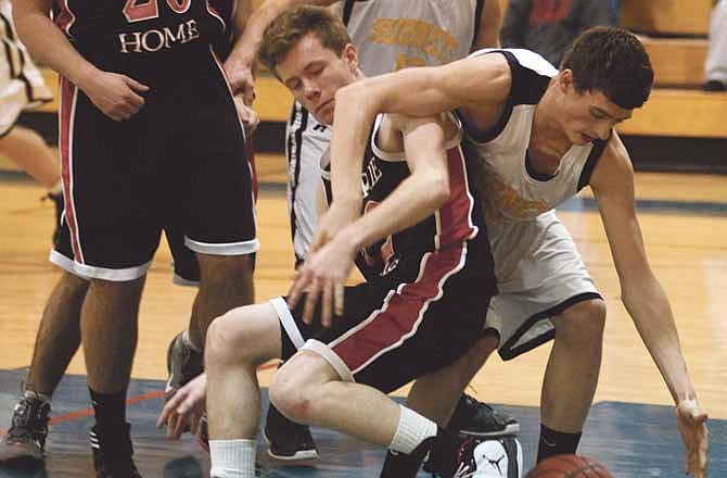 St. Elizabeth's Travis Miner and Prairie Home's Rayce Kendrick tussle for a loose ball Saturday during the championship game of the Calvary Lutheran Tournament at Trinity Lutheran in Jefferson City.