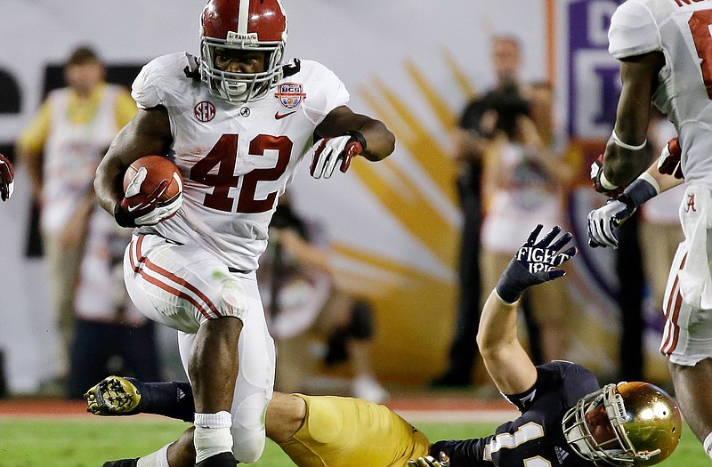 Alabama's Eddie Lacy (42) runs past Notre Dame's Danny Spond (13) during the first half of the BCS National Championship on Monday in Miami.