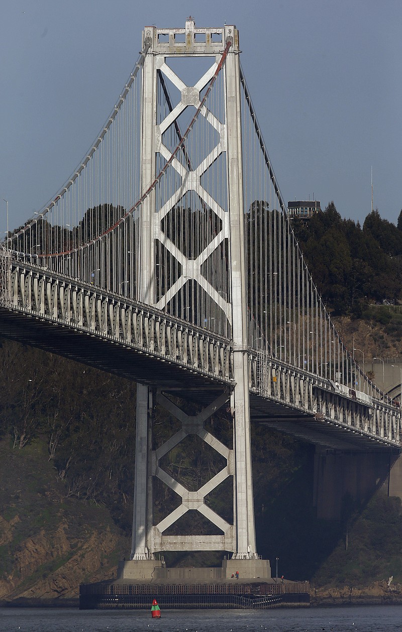 Workers inspect damage to the bottom of a tower on the San Francisco-Oakland Bay Bridge in San Francisco. An empty oil tanker ship, Overseas Reymar, struck the bridge on Monday, but there were no reports of leaking oil and the bridge remained open to traffic, officials said. 