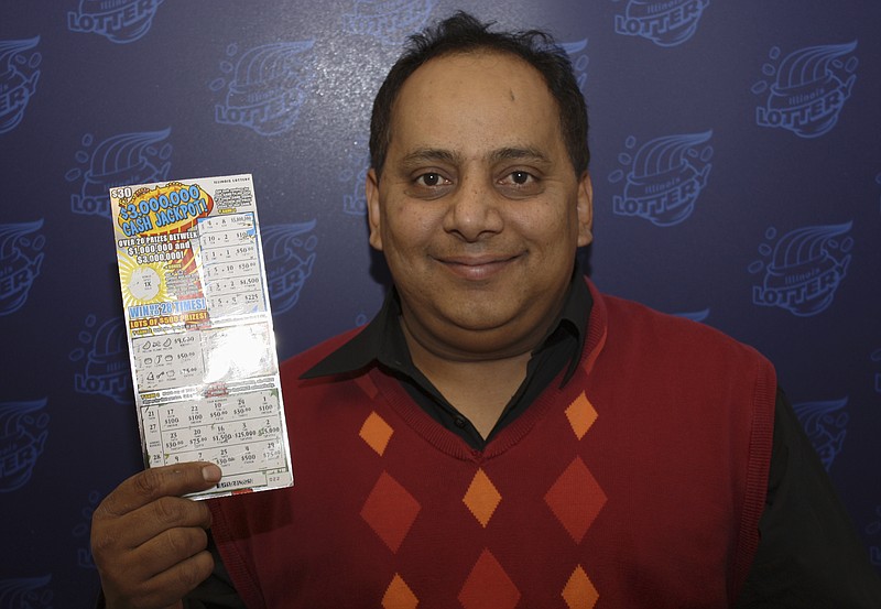Urooj Khan, 46, of Chicago's West Rogers Park neighborhood poses with a winning lottery ticket. The Cook County medical examiner said Monday that Khan was fatally poisoned with cyanide July 20, a day after he collected nearly $425,000 in lottery winnings.