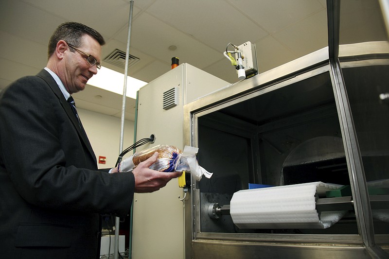 Don Stull, chief executive officer of Microzap, Inc., places a loaf of bread inside a patented microwave that kills mold spores Dec. 6 in Lubbock, Texas. The company claims the technology allows bread to stay mold-free for 60 days.