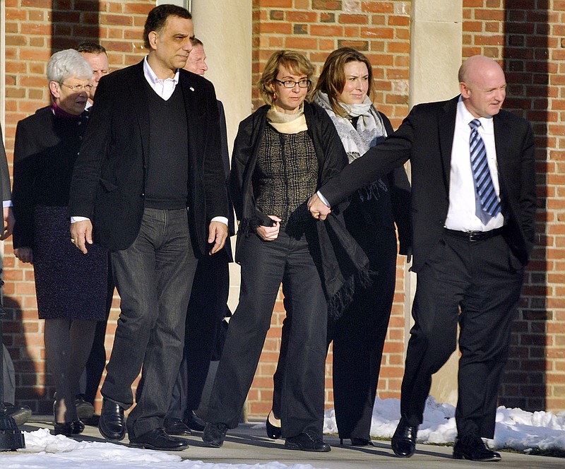 Former U.S. Rep. Gabrielle Giffords, center, holds hands with her husband, Mark Kelly, Jan. 4 while exiting Town Hall at Fairfield Hills Campus in Newtown, Conn. after meeting with Newtown officials. Giffords also met with families of the victims of the Sandy Hook Elementary massacre that left 26 people dead. Tuesday was the second anniversary of the shooting of Giffords.