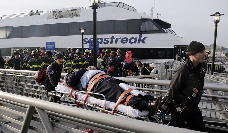 An injured passenger from the Seastreak Wall Street ferry is taken to an ambulance in New York,  Wednesday. The ferry from Atlantic Highlands, N.J., banged into the mooring as it arrived at South Street in lower Manhattan during morning rush hour, injuring as many as 70 people, at least one critically, officials said.