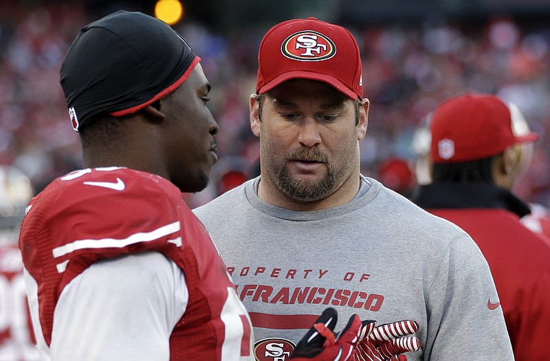 Justin Smith talks with 49ers teammate Aldon Smith during a game against the Cardinals last month in San Francisco.