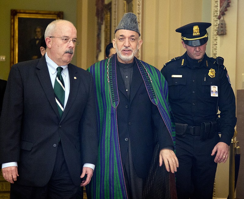 Afghanistan President Hamid Karzai, is escorted Wednesday by Sergeant of Arms of the Senate Terrance Gainer, left, as he walks to a meeting with U.S. senators on Capitol Hill in Washington.