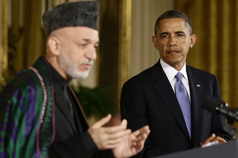 President Barack Obama listens Friday as Afgan President Hamid Karzai speaks during their joint news conference in the East Room at the White House in Washington.
