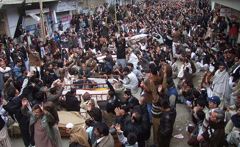 Pakistani Shiite Muslims chant slogans Friday next to the bodies of their relatives awaiting burial, who were killed in Thursday's deadly bombings, at a protest rally in Quetta, Pakistan.
