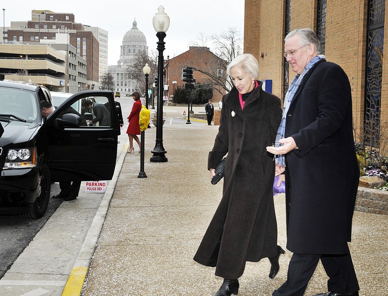 Gov. Jay Nixon escorts his wife, Georganne, to their awaiting vehicle after exiting church. The second-term governor and family attended a brief prayer service Monday morning at First Baptist Church.