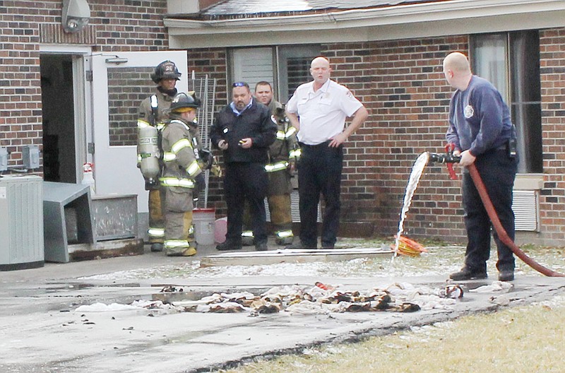 Fulton firemen douse a pile of cleaning rags that combusted into a fire at 2 p.m. Tuesday at Fulton Nursing & Rehab, 1510 North Bluff St. The rags were in a bin in the kitchen when the fire started. The burning rags were moved outside and doused by firemen. With the temperature in the 20s, it was not necessary for the residents and employees to go outside during the incident.