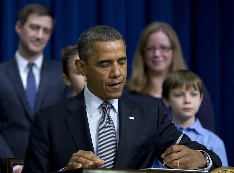 President Barack Obama signs executive orders outlining proposals to reduce gun violence Wednesday in the South Court Auditorium at the White House in Washington.