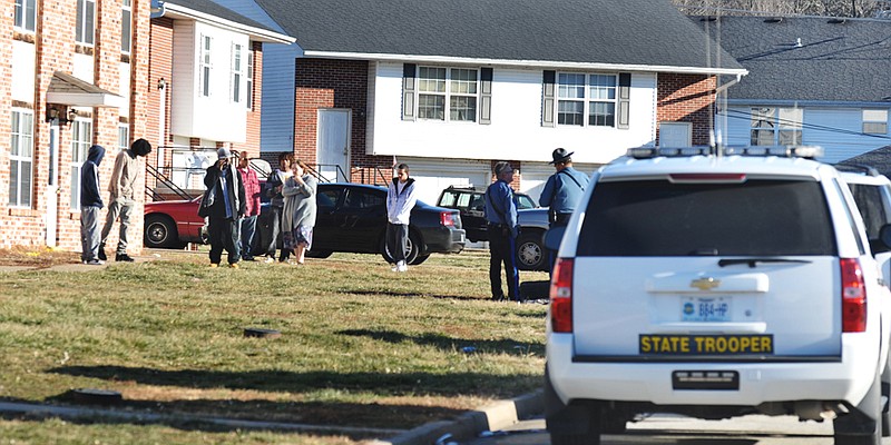 Residents of apartments on Collier Court in western Cole County stand outside on the lawn as members of law enforcement investigate the scene of a shooting Thursday afternoon. 