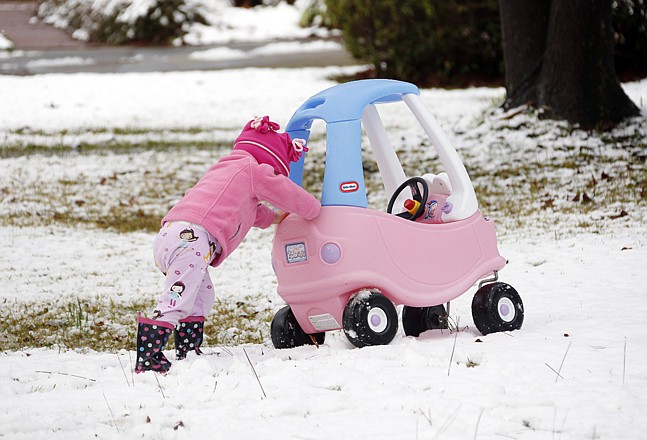 Molly Cleland, 21â„2, pushes her car through the snow Thursday in Jackson, Miss. Central Mississippi was blanketed with 2 to 4 inches of snow.