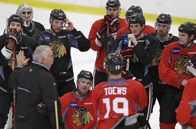 Chicago Blackhawks head coach Joel Quenneville, bottom left, speaks to his team during NHL hockey practice, Monday, Jan. 14, 2013, in Chicago. The Blackhawks are scheduled to begin their lockout-shortened, 48-game regular season against the Los Angeles Kings on Saturday in Los Angeles. 