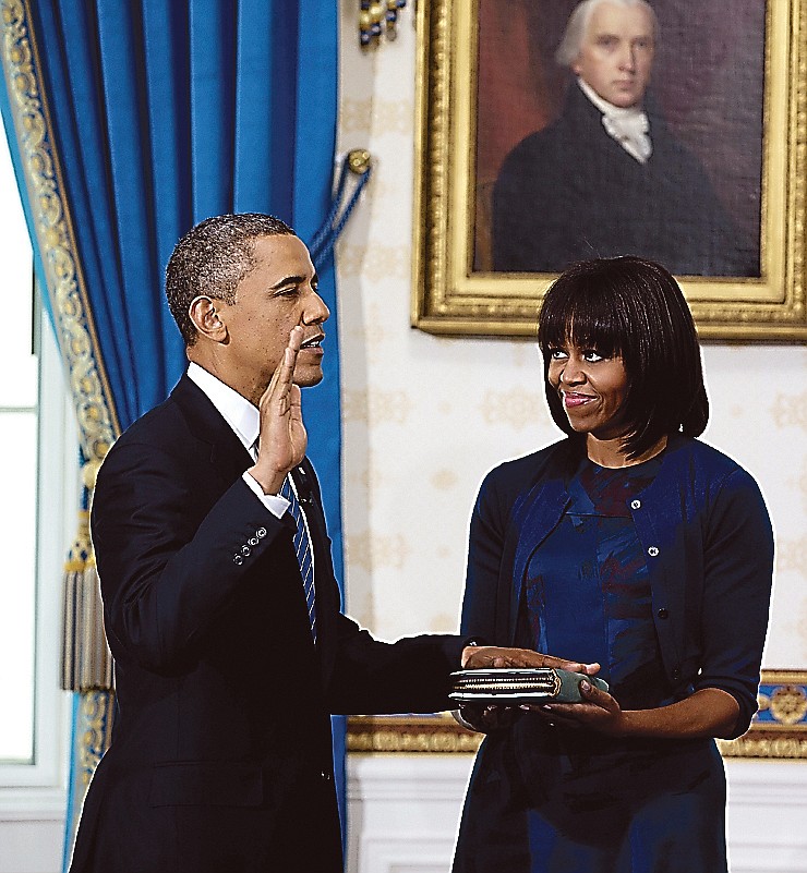 President Barack Obama is officially sworn-in by Chief Justice John Roberts, not pictured, in the Blue Room of the White House on Sunday as first lady Michelle Obama holds the Robinson Family Bible.