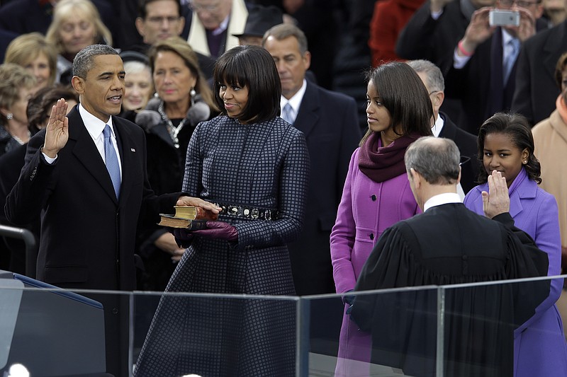 President Barack Obama receives the oath of office from Chief Justice John Roberts at the ceremonial swearing-in at the U.S. Capitol during the 57th Presidential Inauguration in Washington, Monday, Jan. 21, 2013. First Lady Michelle Obama holds the bible as daughters Malia and Sasha watch.
