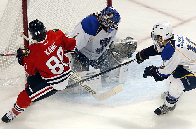 Blues goalie Brian Elliott (1) makes a save on a shot by Blackhawks right winger Patrick Kane (left) as center Andy McDonald also defends during the third period Tuesday in Chicago. The Blackhawks won 3-2. 