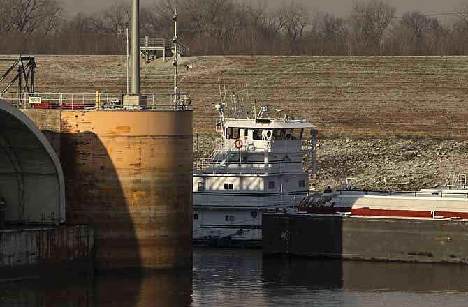 A towboat pushes a barge through Lock & Dam 27 early Wednesday, Jan. 23, 2013, in Granite City. Ill. A key stretch of the Mississippi River reopened to shipping Wednesday after hasty repairs were made to a lock damaged by a barge, marking the latest victory for stewards of the drought-plagued waterway they have maneuvered to keep open. (AP Photo/St. Louis Post-Dispatch, Erik M. Lunsford)