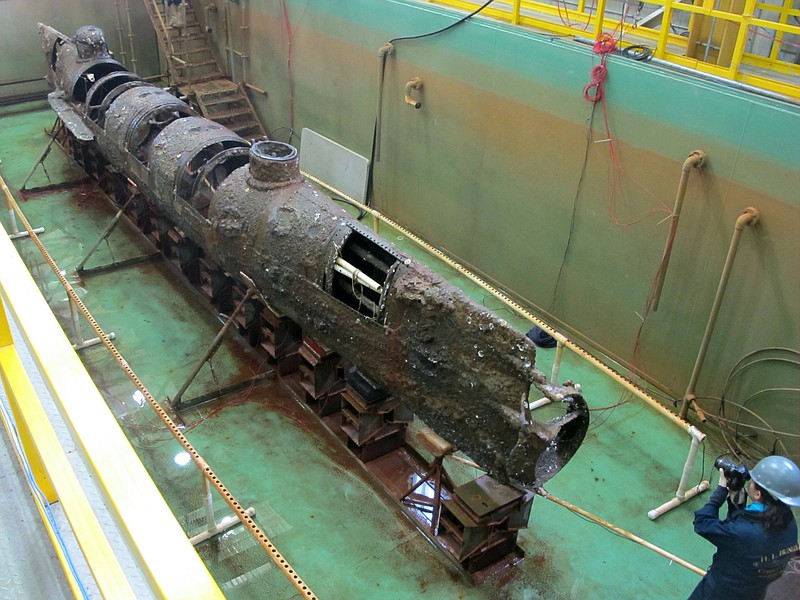 The Confederate submarine H.L. Hunley sits in a conservation tank after a steel truss that had surrounded it was removed. Scientists say a pole on the front of the submarine designed to plant explosives on enemy ships may hold a key clue to its sinking during the Civil War. 