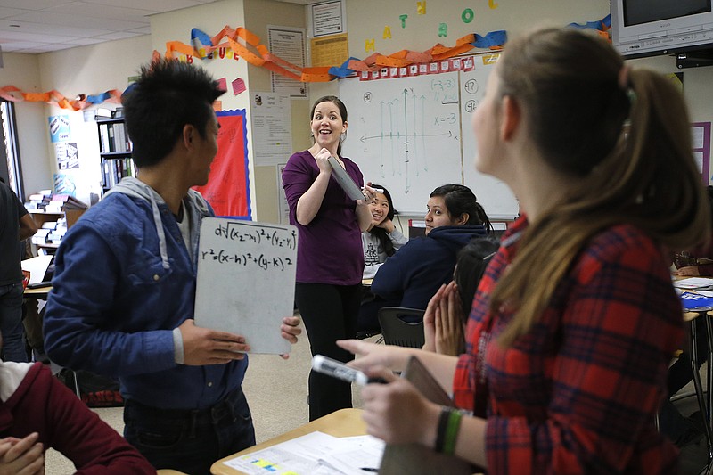 Teacher Crystal Kirch, center, talks to her students in her pre-calculus class at Segerstrom High School in Santa Ana, Calif., Wednesday, Jan. 16, 2013. A growing number of teachers are implementing what is known as "flipped learning," in which students learn lessons as homework, mostly through online videos produced by teachers, and use classroom time to practice what they learned. 