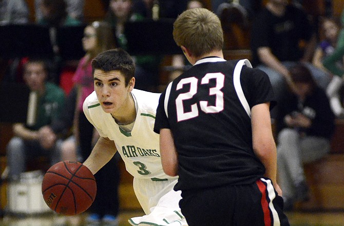 Logan Bax of Blair Oaks looks down the court as he tries to drive past Tyler Kempker of Eugene during Tuesday night's game in Wardsville.