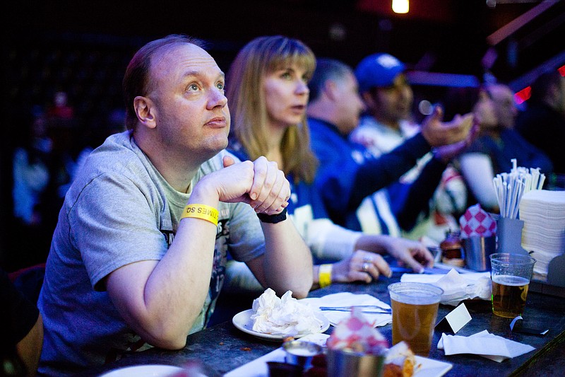 Ron Blydenburgh, of Hampton Bays, N.Y., watches the broadcast of the 2012 NFL football Super Bowl. In 2013, more Super Bowl advertisers are ditching the tradition of keeping spots secret and are instead releasing shortened versions of their Game Day spots called "teasers" to get pre-game buzz going on social media sites like Facebook and Twitter.