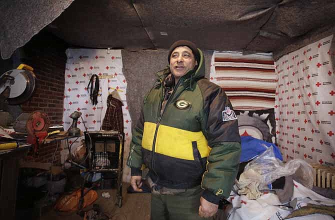 In this photo taken Jan. 23, 2013, Eddie Saman shows how he insulated his home with blankets donated by the Red Cross, in the Staten Island borough of New York. The house was badly damaged by Superstorm Sandy and will have to be renovated. Three months after Sandy struck, thousands of storm victims in New York and New Jersey are stuck in limbo. Waiting for the heat to come on, for insurance money to come through, for loans to be approved. Waiting, in a broader sense, for their upended lives to get back to normal.