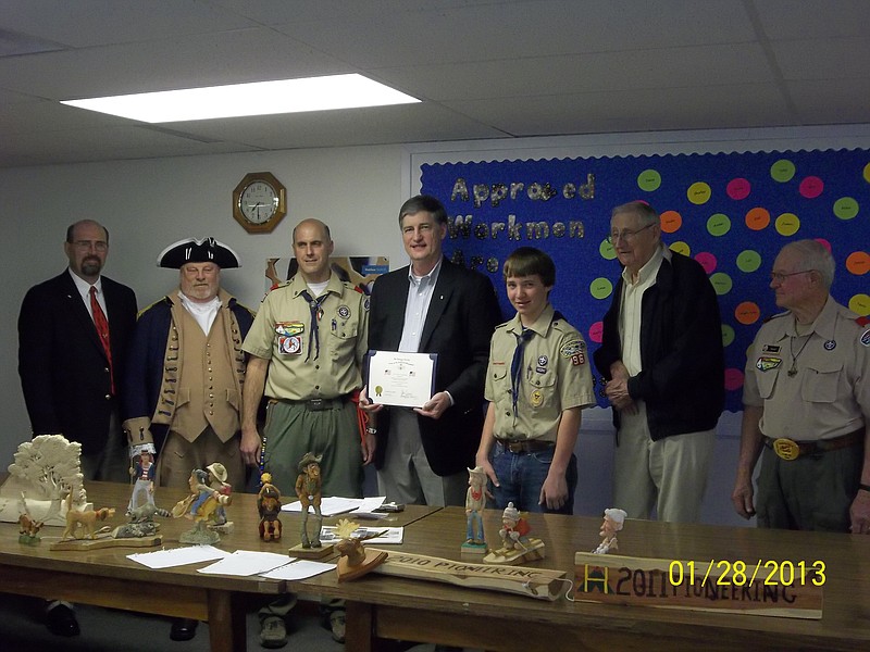 The Christopher Casey Chapter of the Missouri Society of the sons of the American Revolution has commended Russellville's Troop 96 of the Boy Scouts of America for its recurrent American flag displays along Route C during patriotic holidays. Pictured from left are: Joe Coy, Ernie Mowry, Jason Ford, scoutmaster, Steve Neuman, David Shelden, senior patrol leader, and Tom Holt, who did the woodworking in the foreground. 