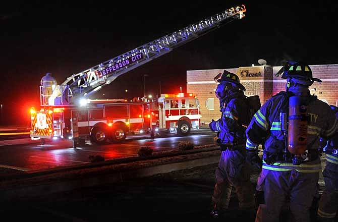 Jefferson City firefighters survey the scene while responding to a fire at Oscar's Classic Diner at 2118 Schotthill Woods Road early Thursday morning. Fire department officials at the scene reported the fire appeared to have started in the restaurant's kitchen shortly after midnight.