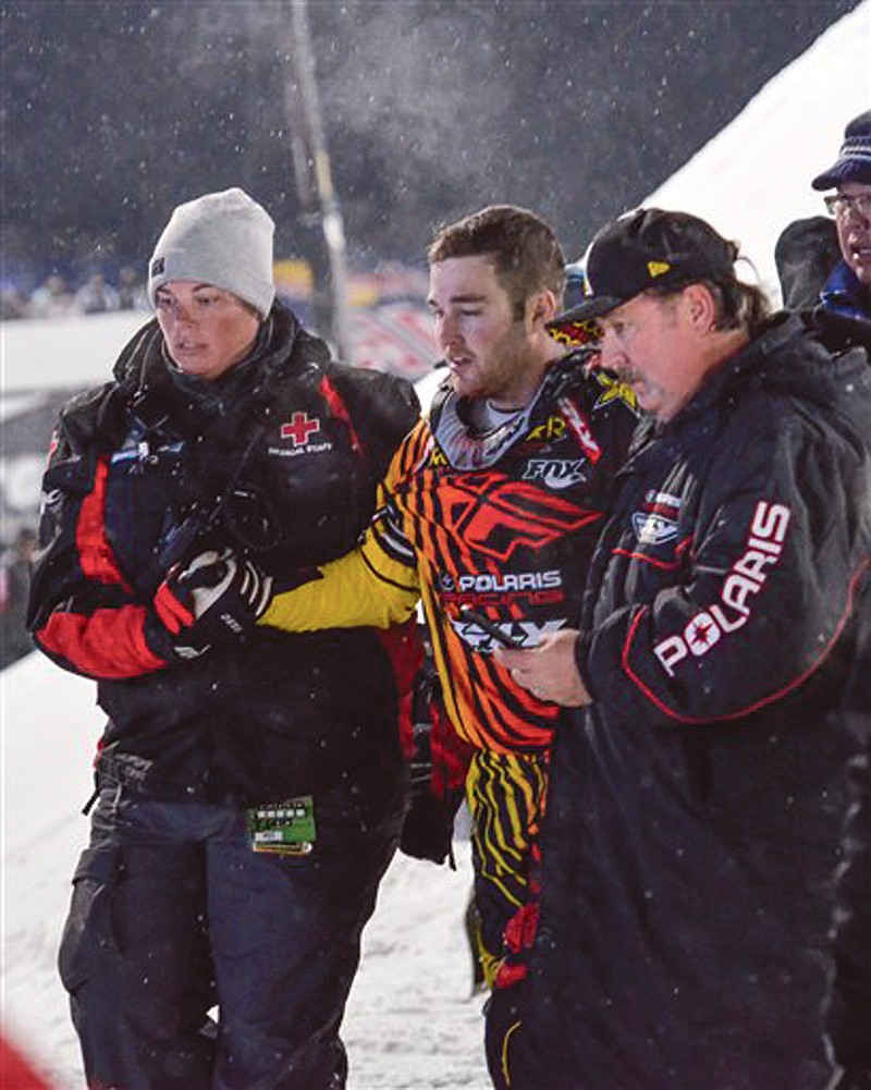 Caleb Moore is helped off the snow following his crash during the ESPN Winter X Games snowmobile freestyle competition in Aspen, Colo. Moore died Thursday from injuries suffered during the crash.