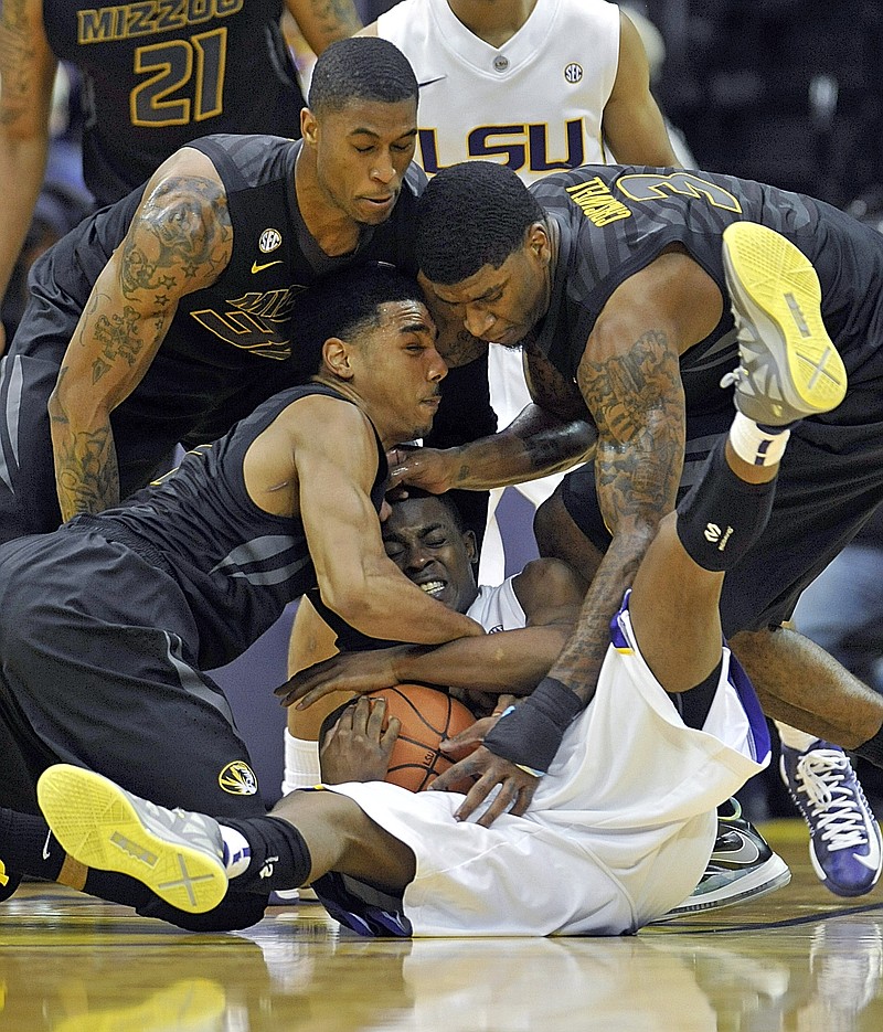 LSU guard Anthony Hickey (1) is smothered after going after a loose ball by Missouri's Phil Pressey (bottom left) Earnest Ross (top left) and Tony Criswell during the second half Wednesday at the Pete Maravich Assembly Center in Baton Rouge, La.