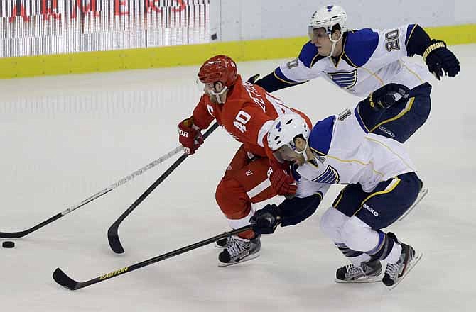 Detroit Red Wings center Henrik Zetterberg (40), of Sweden, controls the puck between the defense of St. Louis Blues left wing Alexander Steen (20) and center Andy McDonald during the third period of an NHL hockey game in Detroit, Friday, Feb. 1, 2013.