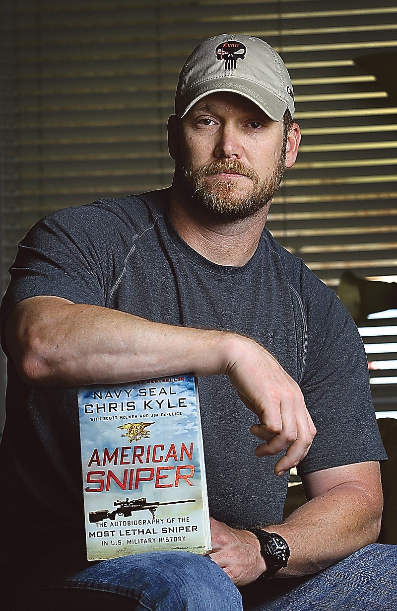 Former Navy SEAL Chris Kyle poses with his book "American Sniper" in Midlothian, Texas.