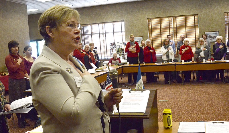 Leading the Pledge of Allegiance at the Daughters of the American Revolution meeting is Marti Crawford.